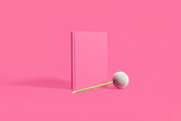 istock Pink hardcover notebook and green pen on pink 1148204055
