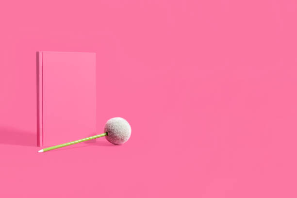 istock Pink hardcover notebook and green pen offset on a pink background 1148204076