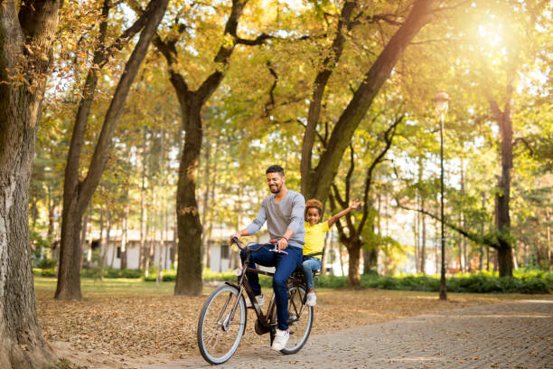 padre e hija disfrutando de paseo en bicicleta en la naturaleza. - park and ride fotografías e imágenes de stock