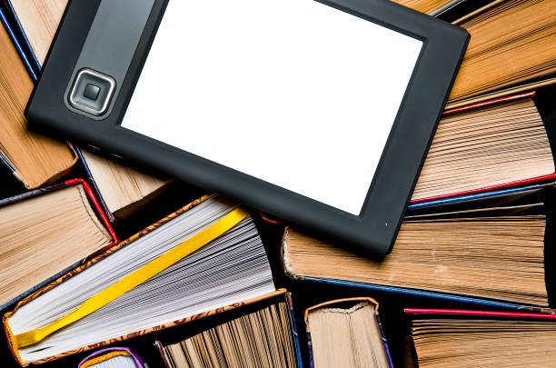 istock The e-book with a white screen lies on the open multi-colored books that lie on a dark background, close-up 1148206868