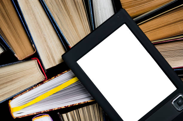 istock The e-book with a white screen lies on the open multi-colored books that lie on a dark background, close-up 1148206879