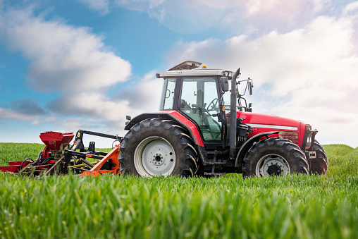 Agricultural field being mowed by a farmer.