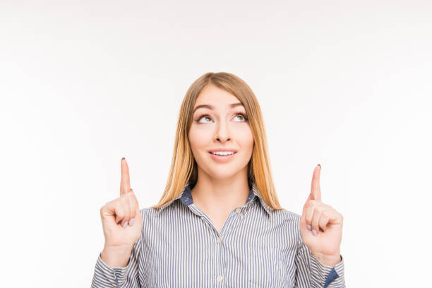 istock Smiling woman pointing up 1148207394
