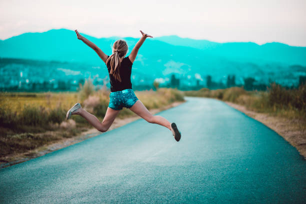 istock Happy Female Jumping On The Road 1148207968