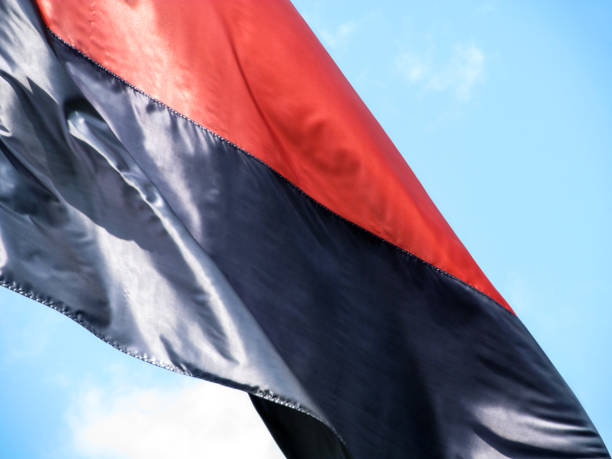 istock Black and red satin banner flying against the blue sky 1148207971