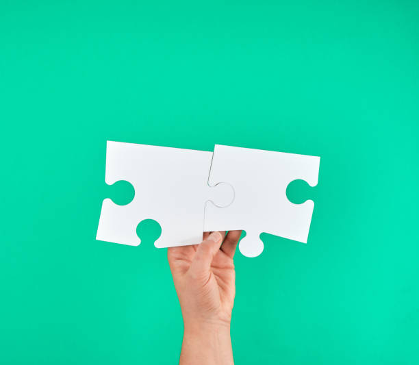 istock white big puzzle in female hand on green background 1148208303