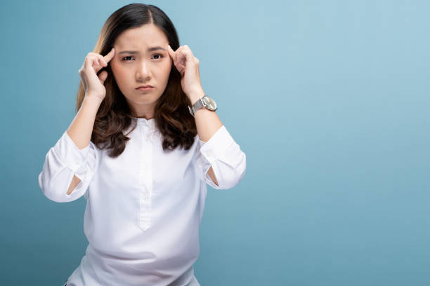 istock Woman has headache isolated over blue background 1148208321