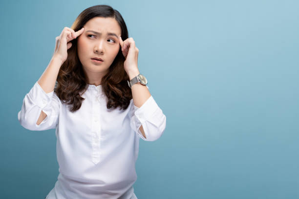 istock Woman has headache isolated over blue background 1148208336