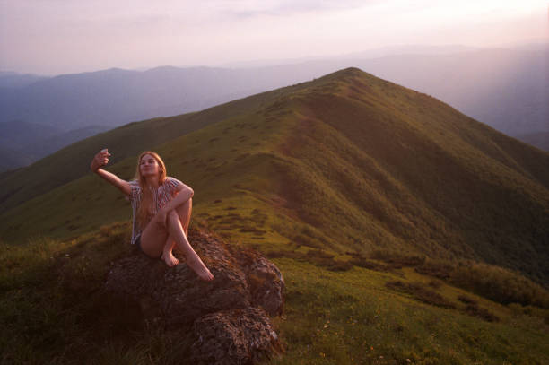 istock Young woman doing selfies on a phone in the mountains 1148208489
