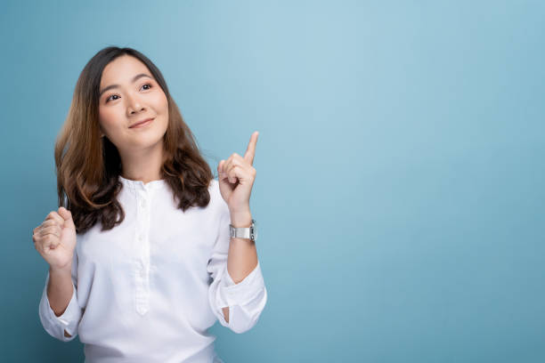 istock Happy woman thinking and standing isolated over blue background 1148208650