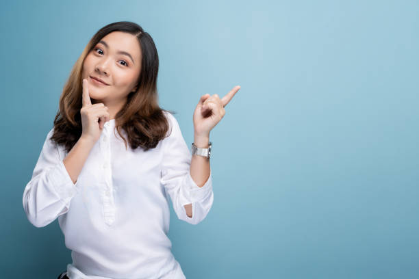 istock Happy woman thinking and standing isolated over blue background 1148208652