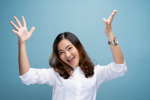 istock Happy woman make winning gesture isolated over blue background 1148208658