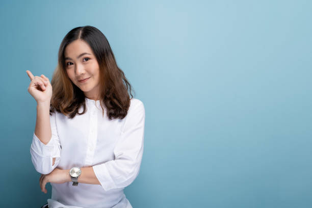 istock Happy woman thinking and standing isolated over blue background 1148208664