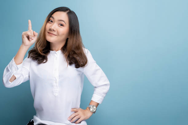 istock Happy woman thinking and standing isolated over blue background 1148208694