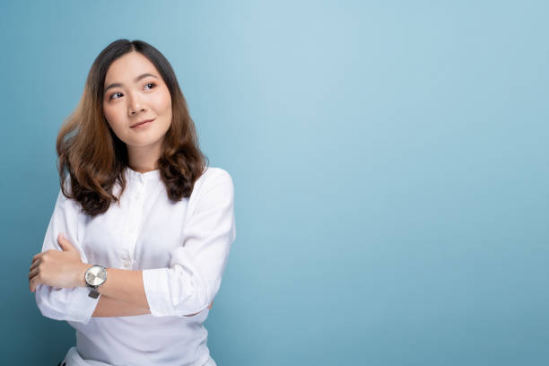 istock Happy woman thinking and standing isolated over blue background 1148208696