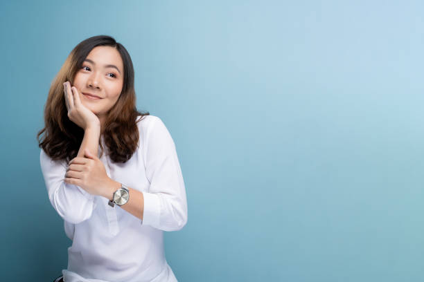 istock Happy woman thinking and standing isolated over blue background 1148208791