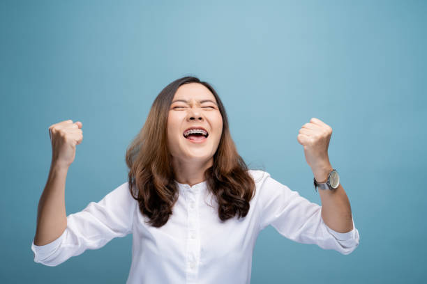 istock Happy woman make winning gesture isolated over blue background 1148208812