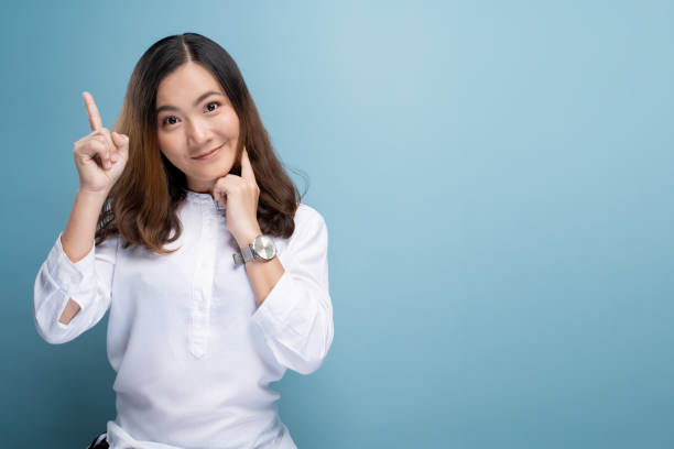 istock Happy woman thinking and standing isolated over blue background 1148208830