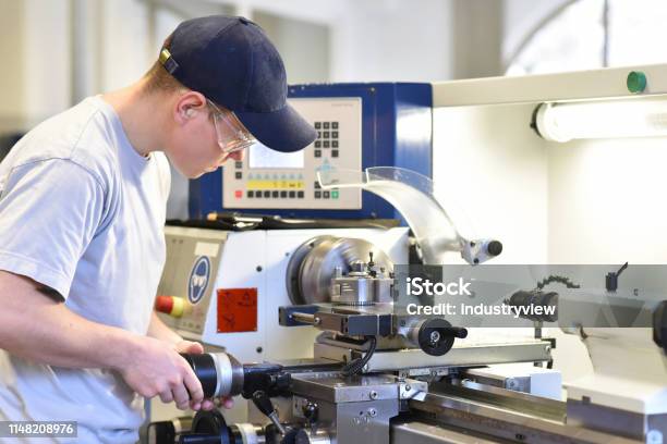 Junge Auszubildende In Der Berufsausbildung An Einer Drehmaschine In Der Branche Stockfoto und mehr Bilder von Berufliche Beschäftigung