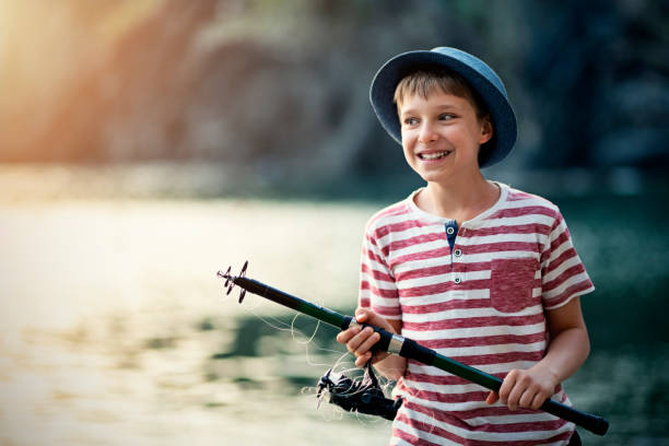 rapaz pequeno engraçado com a haste de pesca tangled - fishing rod fishing fishing reel casting - fotografias e filmes do acervo