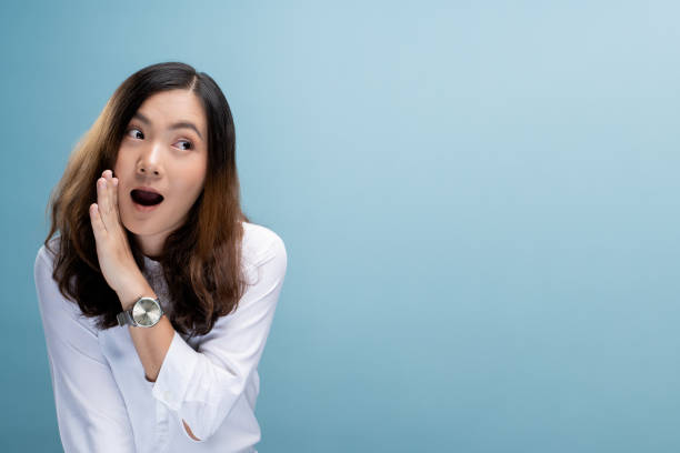 istock Woman make gossip gesture isolated over blue background 1148212092