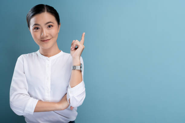 istock Happy woman thinking and standing isolated over blue background 1148212185