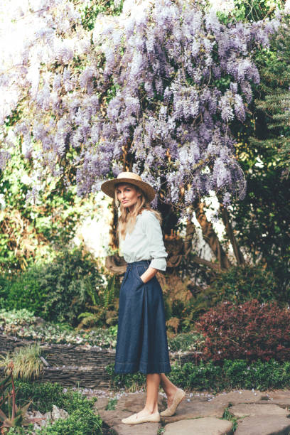 istock Woman in a hat with wisteria 1148214015