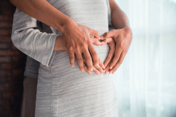 istock couple hand making heart shape on pregnant belly 1148214154