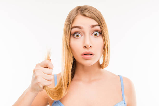 istock Young shocked woman showing her damaged split ends 1148217069
