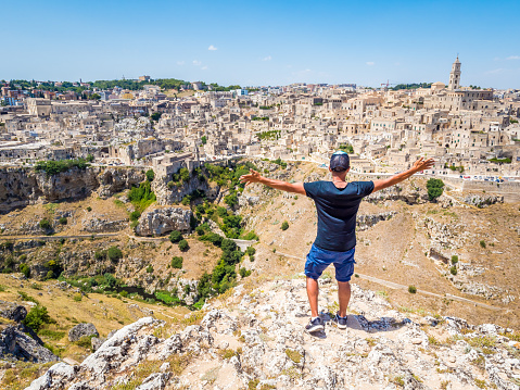 Man looking out over the landscape of the Sassi di Matera, prehistoric historic center, UNESCO World Heritage Site, European Capital of Culture 2019 (wide)