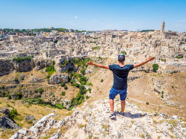 Man looking out over the landscape of the Sassi di Matera Man looking out over the landscape of the Sassi di Matera, prehistoric historic center, UNESCO World Heritage Site, European Capital of Culture 2019 (wide) murge photos stock pictures, royalty-free photos & images