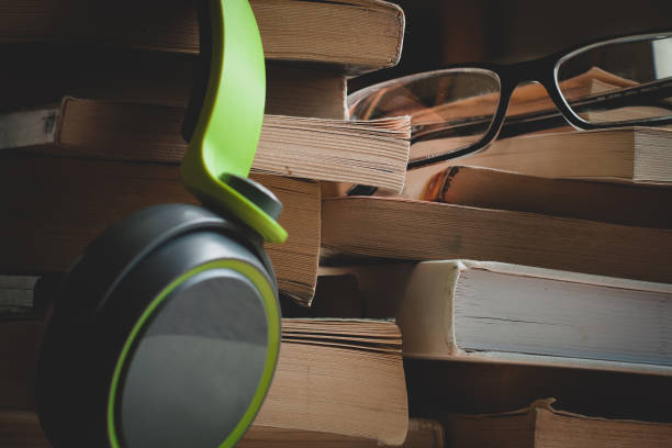 istock headphones and eyeglasses on a stack of books 1148220031