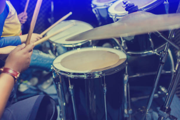 istock hands of teacher with wooden drumsticks guiding boy in drum learning tutorial in recording studio at music academy 1148220741