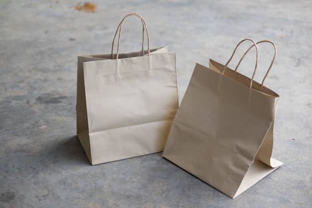 istock Two kraft paper shopping bags on cement background 1148222251