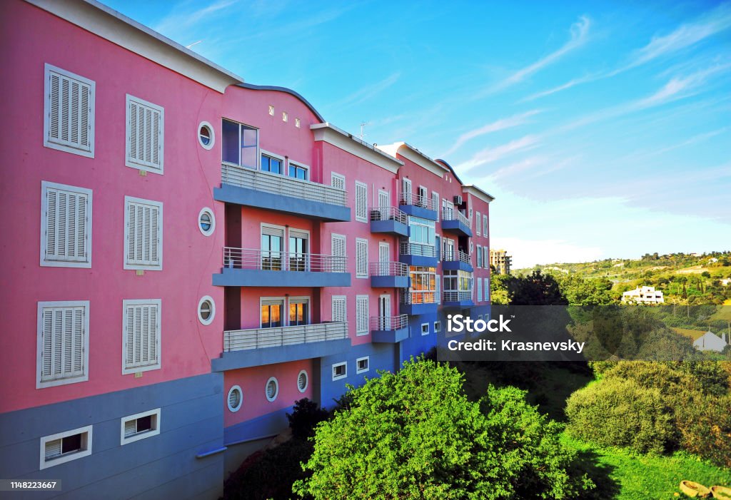 View of pink modern house throug the window frame Facade of pink house in Lagos town, Portugal Balcony Stock Photo