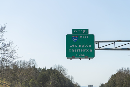 Road sign above highway road of Interstate 64 West with direction to exit 191 in 1 mile to Lexington and Charleston in Virginia