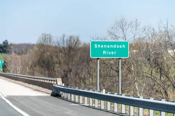 Green road sign for Shenandoah river in vally near Happy Creek in Virginia in summer or spring with trees