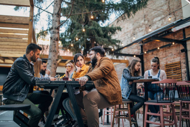istock Group of young joyful friends having fun in a pub 1148224337