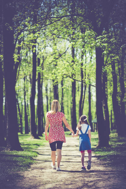 istock Mother and daughter walking in woods 1148226987