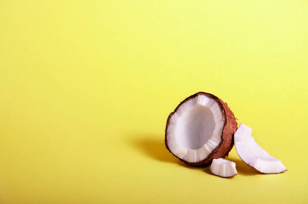istock Half Coconut on Yellow Background. Exotic Food. Summer Tropical Concept. Copy Space For Your Text 1148227099