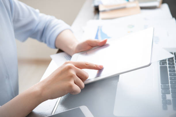 istock Business concept. Woman using tablet for project with digital device in office desk. Backlighting, sun glare effect, close up, side view, copy space 1148230997