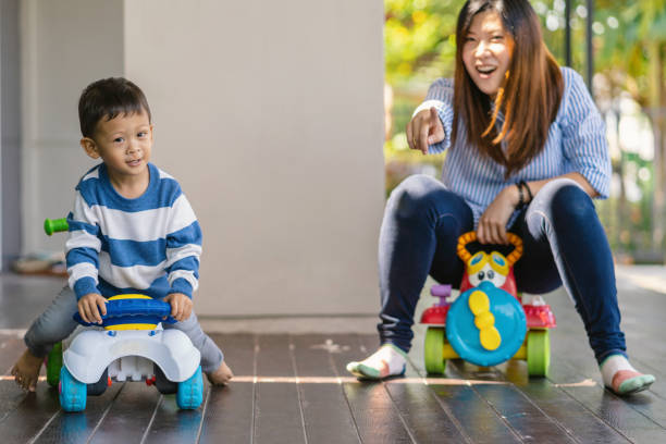 asiatique seule maman avec fils jouent avec le jouet de voiture ensemble quand vivant dans la maison moderne pour l’auto-apprentissage ou l’école à la maison, la famille et le concept de mère unique, focus sélectif - brown boy photos et images de collection