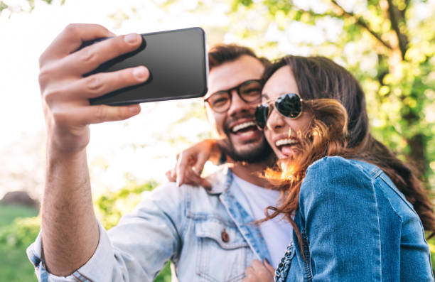 istock Cheerful couple taking selfie in park 1148231390