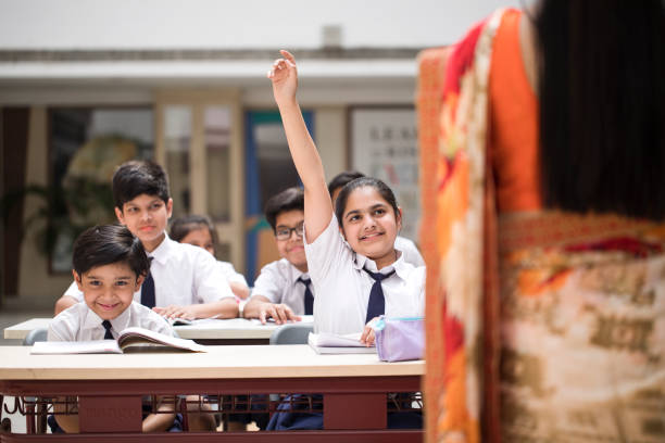 istock Girl raising hand in classroom 1148232257