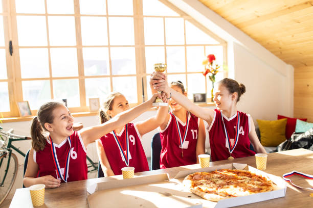 jogadores de basquetebol adolescentes que comemoram ganhar um troféu - time table - fotografias e filmes do acervo