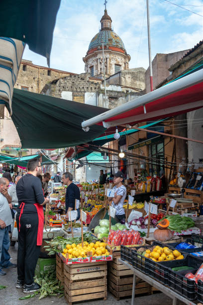 PALERMO, ITALY - APRIL 26: Activity in Ballaro Market in Palermo, Italy with Carmine Maggiore Church in the background on April 26, 2018