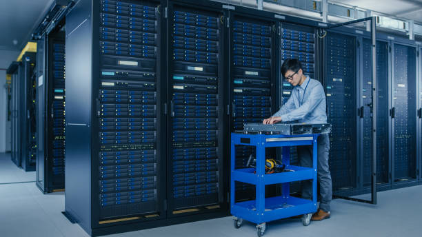istock In the Modern Data Center: IT Technician Working with Server Racks, on a Pushcart Various Equipment Needed for Installing New Hard Drives, Doing Hardware Maintenance and Diagnostics. 1148233811