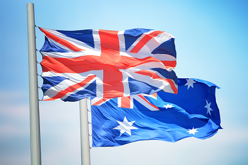 Flags of UK and Australia against the background of the blue sky