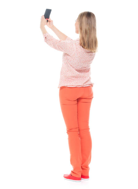 istock Good looking white female standing on white background - taking a selfie 1148235393