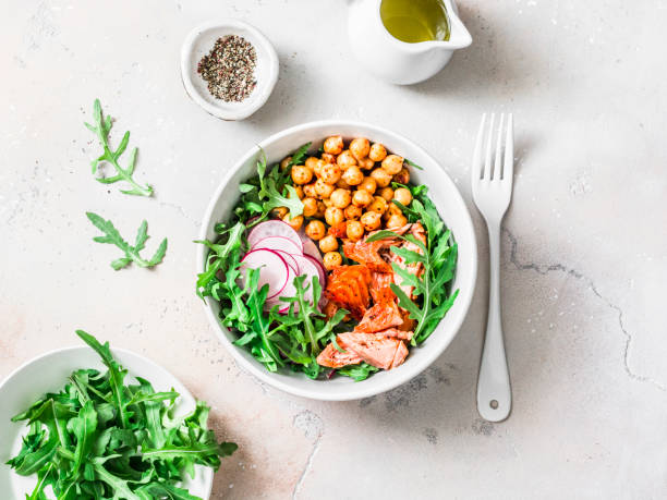 istock Spicy chickpeas, baked salmon, crispy radish, arugula salad on a light background, top view 1148238609